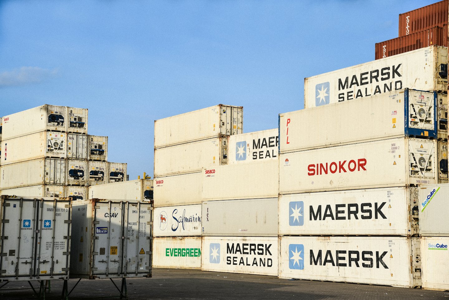 Container marittimi impilati in un deposito industriale.