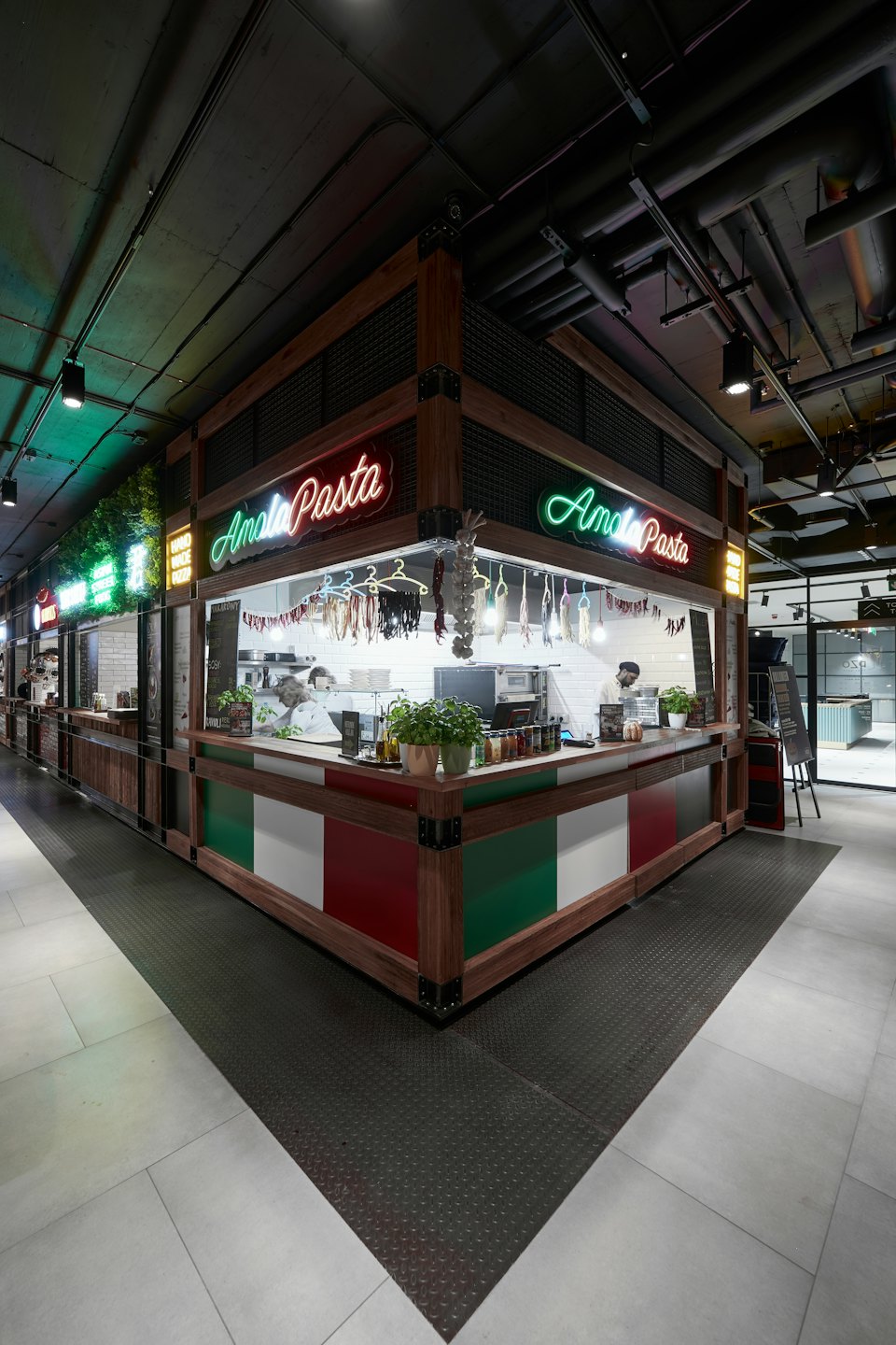 Bancarella di pasta Amato in un moderno food hall con cuochi che preparano il cibo.